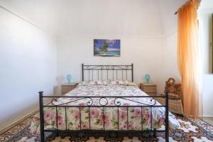 um quarto com uma cama com colcha floral em La casa di pietra location Rosy em Monopoli