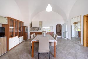 uma cozinha e sala de jantar com mesa e cadeiras em La casa di pietra location Rosy em Monopoli