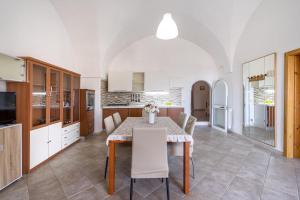Una cocina y un comedor con mesa y sillas. en La casa di pietra location Rosy, en Monopoli