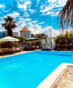ein großer blauer Pool mit Stühlen und Sonnenschirmen in der Unterkunft Royal Club Hotel - Aqua Poolside Bliss in Kamenitsotaíika