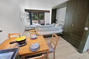 una cucina e un soggiorno con tavolo e divano di Studio rénové à côté des pistes a Saas-Fee