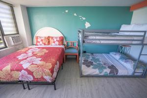 a room with two bunk beds and a bed and a chair at Diamond, Ocean, and Canal view Affordable Family House in Honolulu