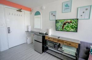 a living room with a tv on a wall at Diamond, Ocean, and Canal view Affordable Family House in Honolulu