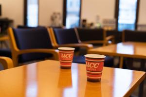 two cups of coffee sitting on top of a table at Business Hotel Ueno in Yamaguchi