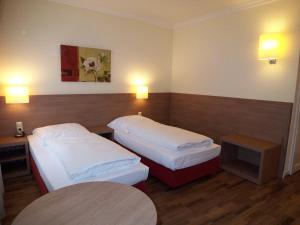ハンブルクにあるホテル マリエンタール ガルニのベッド2台とテーブルが備わるホテルルームです。