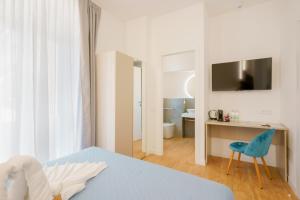 a bedroom with a bed and a desk and a chair at Aqua Comfort Rooms - Eja Sardinia in Cagliari