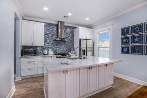 a kitchen with white cabinets and a counter top at Luxury Designer Villa by the Beach Bright Beautiful Brand New in Galveston