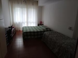 mały pokój z 2 łóżkami i oknem w obiekcie la sosta w Arenzano