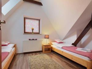 a attic room with two beds and a window at Apartament Pod Giewontem in Zakopane