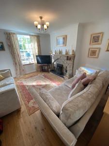 ein Wohnzimmer mit einem Sofa und einem Kamin in der Unterkunft Clearwater 17th Century Cottage in Richmond