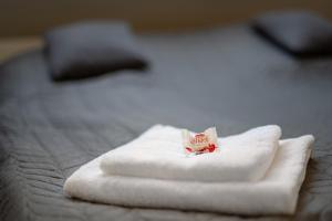 une pile de serviettes blanches assises sur un lit dans l'établissement Ágoston Apartman, à Pécs