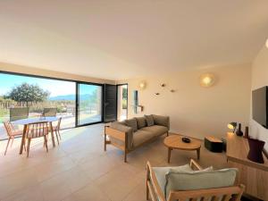 een woonkamer met een bank en een tafel bij Casa di Bà - villa 2 chambres avec piscine à 10 minutes des plages in Afa