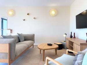 ein Wohnzimmer mit einem Sofa und einem Tisch in der Unterkunft Casa di Bà - villa 2 chambres avec piscine à 10 minutes des plages in 