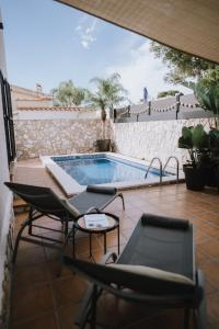 a patio with chairs and a swimming pool at Oliveres3 in L'Ampolla