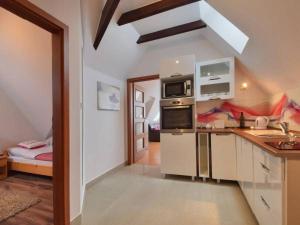 uma cozinha com electrodomésticos brancos e uma sala com uma cama em Apartament Pod Giewontem em Zakopane