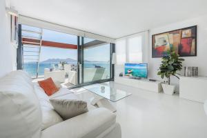 a living room with a white couch and a glass table at Ático Londres Derecha in Port de Pollensa