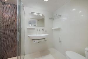 a white bathroom with a sink and a shower at Ático Londres Derecha in Port de Pollensa +3 photos