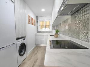 - une cuisine blanche avec un lave-linge et un évier dans l'établissement APARTBEACH EUROPEOS 2 MUY LUMINOSO y GRAN TERRAZA, à La Pineda