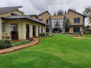 dom z trawnikiem przed nim w obiekcie Florances Rest House w mieście Nairobi