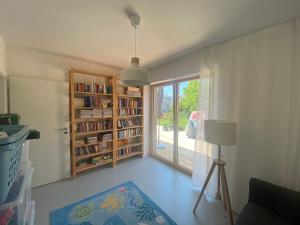 a living room with a window and a book shelf at Das Lavendelhaus Weißenstadt Unser modernes und gemütliches Ferienhaus im Fichtelgebirge in Weißenstadt