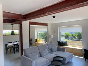 a living room with a couch and a table at Das Lavendelhaus Weißenstadt Unser modernes und gemütliches Ferienhaus im Fichtelgebirge in Weißenstadt