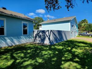 a house with a fence in front of a yard at Luxury Designer Villa by the Beach Bright Beautiful Brand New in Galveston