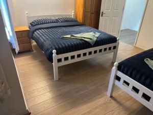 1 Schlafzimmer mit 2 Betten und Holzboden in der Unterkunft Rahal Concord in London