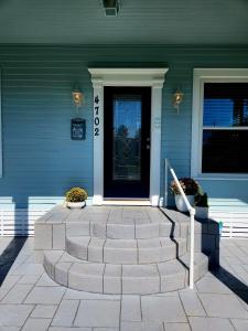 a house with a blue door and a stone walkway at Luxury Designer Villa by the Beach Bright Beautiful Brand New in Galveston