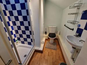 uma casa de banho com um chuveiro, um WC e um lavatório. em CosyHomeStay Evesham Spacious home W/Free Parking & WiFi em Evesham