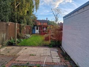 an empty backyard with a fence and a yard at CosyHomeStay Evesham Spacious home W/Free Parking & WiFi in Evesham