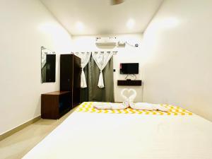 - une chambre avec un grand lit blanc et une télévision dans l'établissement Hotel Baga Bay 200 Meters From Baga Beach, à Baga