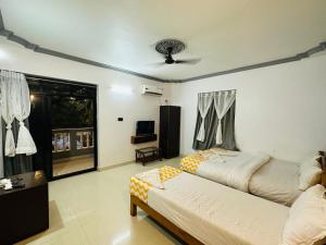 a bedroom with two beds and a ceiling fan at Hotel Baga Bay 200 Meters From Baga Beach in Baga