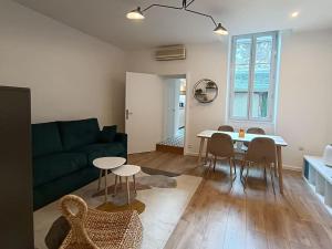 a living room with a couch and a table and chairs at Cocon haut de gamme à Nevers in Nevers