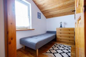 a small bedroom with a bench and a window at Apartament Miriada 16 in Rowy