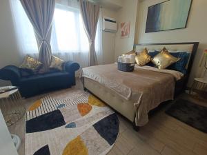 um quarto com uma cama, um sofá e uma cadeira em Magen's Place em Bacolod
