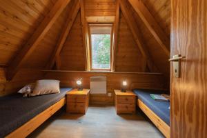 - une chambre avec 2 lits dans une cabane en bois dans l'établissement VS 6 - Strandvogt 2 Komfort, à Dorum Neufeld