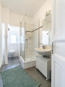 a white bathroom with a sink and a shower at Cozy Apartment in Wiesbaden in Wiesbaden