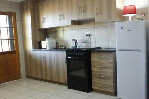 a kitchen with a black stove and a refrigerator at Tarentaal in Bloemfontein