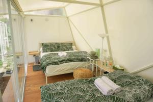 a room with two beds in a tent at Over Easy Glamping Site in Bandung