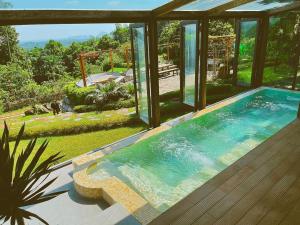 una piscina en una casa con vistas al jardín en A Little Hill Retreat en Hòa Bình