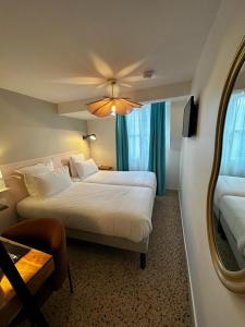 パリにあるTrendy Canettes Hotelの大きなベッドと鏡が備わるホテルルームです。