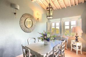a dining room with a table and chairs and a mirror at La Loggia in Castelfalfi