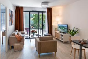 uma sala de estar com um sofá e uma televisão em DOMITYS LYON LA MANUFACTURE em Lyon