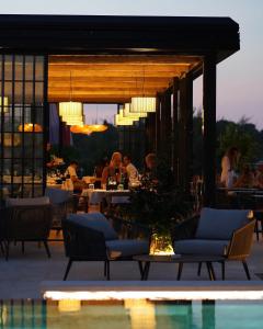 restauracja z ludźmi siedzącymi przy stołach i basenem w obiekcie DUNATOVI DVORI Heritage Hotel w mieście Preko
