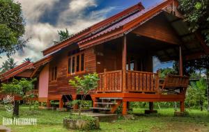 a wooden house with a large front porch at Phet Ban Suan Hotel in Ko Chang