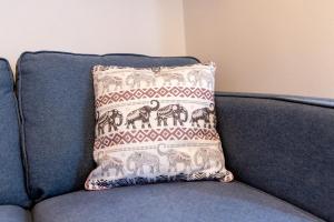 a pillow sitting on top of a blue couch at Newark Apartments: Ideal for Contractors with Parking in Balderton