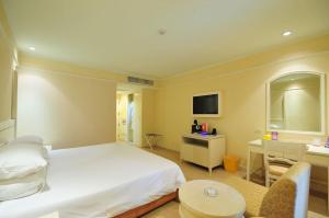 um quarto com uma cama branca e uma secretária em The Palazzo Hotel em Banguecoque