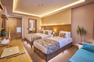 ein Hotelzimmer mit zwei Betten und einem Tisch in der Unterkunft Atro Hotel in Istanbul