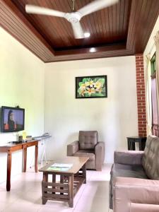 a living room with a couch and a table at Jasmine Villa in Pantai Cenang