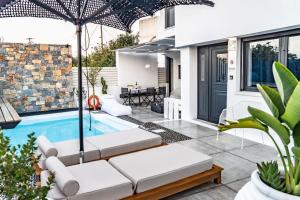 a patio with a pool and an umbrella at Smaris Collection Luxury villas/Cosmopolitan villa,heated pool in Sissi